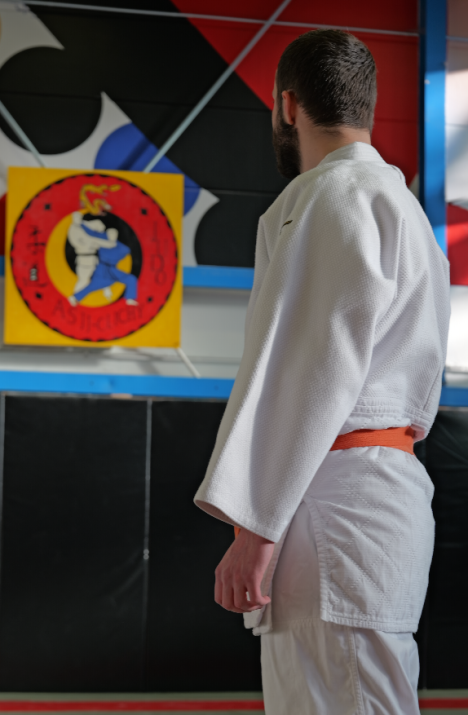 Coach d’arts martiaux en kimono dans un dojo avant un entraînement