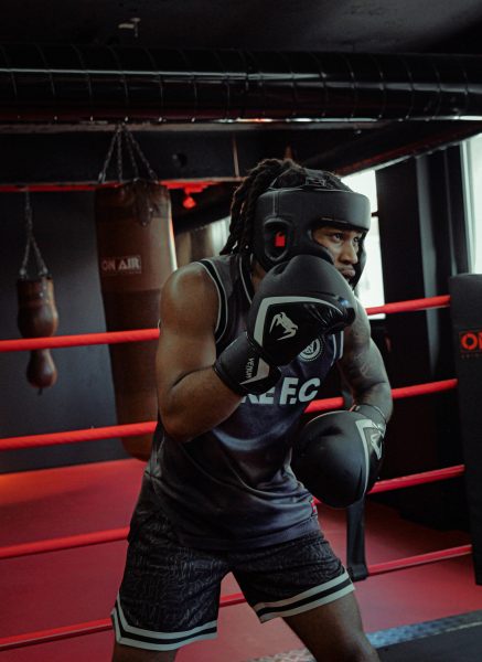 Boxeur équipé en pleine séance de sparring, gardant sa défense dans une salle de boxe