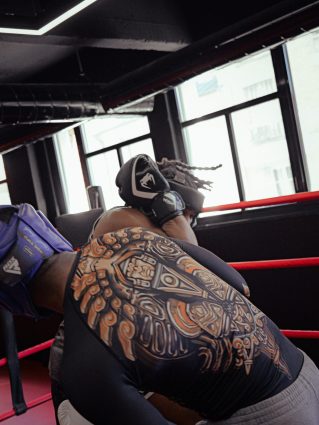 Deux boxeurs en plein échange intense dans une salle de sport publique, entraînement de boxe dynamique